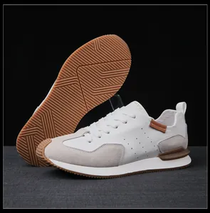 Detalle de zapatillas de cuero blanco para hombre con suela de goma antideslizante y ante.