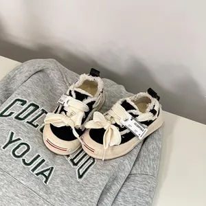 Detailed view of stylish black and beige infant canvas shoes with thick laces