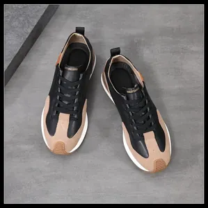 Vista superior de zapatillas de hombre en cuero negro y tostado sobre fondo gris