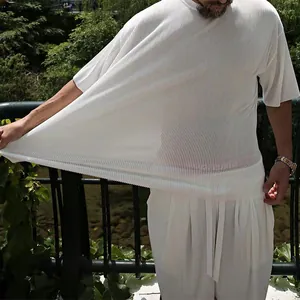 Macro view of white vertical pleated texture on loose summer casual men's outfit