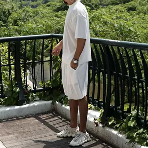 Outdoor detail of men's white pleated vertical stripe loose summer short set