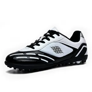 Scarpe da calcio professionali antiscivolo per ragazzi in bianco e nero.