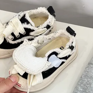 Macro view of baby canvas shoes featuring frayed edge design and thick soft rubber soles