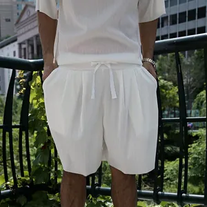 Close-up of men's white pleated casual shorts and short sleeve shirt set with drawstring
