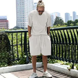 Men's off-white pleated short sleeve and shorts casual set in outdoor urban setting
