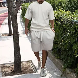 Street style view of a men's white casual textured t-shirt and loose shorts set.