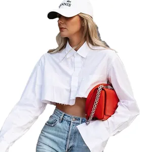 Trendy white long-sleeve cropped shirt with raw hem and loose fit.
