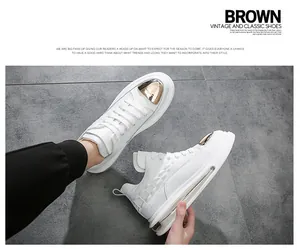 Detailed view of white leather high-top sneakers with gold accents and air cushion