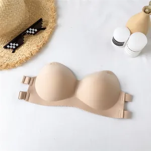 Nahaufnahme eines beigen, trägerlosen, nahtlosen Bandeau-BHs mit Sommer-Requisiten