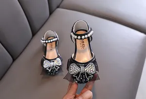 Detail van zwarte prinsessenschoenen voor meisjes met strik van strass