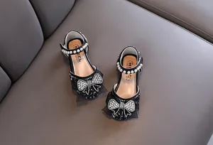 Detail van zwarte prinsessenschoenen voor meisjes met een strik van stras en parels