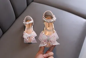 Close-up van roze prinsessenschoenen voor meisjes met een tule strik en strass