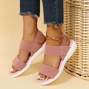 Primer plano de sandalias de cuña flyknit rosas para mujer con suela blanca cómoda