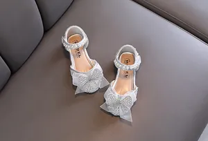 Detailweergave van zilveren prinsessensandalen voor meisjes met strasstrik