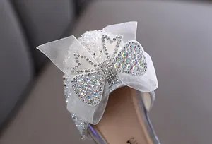 Detailopname van de elegante strass-vlinderstrik op zilveren prinsessenschoenen voor meisjes
