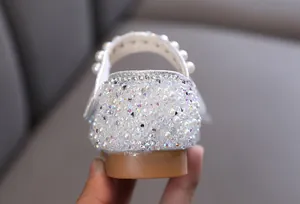 Macrodetail van een witte prinsessenschoen voor meisjes met parels en fonkelende strass