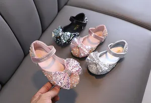 Detailed view of girls' sparkling sequin Mary Jane shoes with elegant bows.