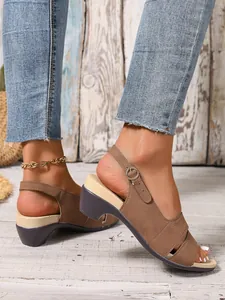 Close-up of brown suede-like peep-toe sandals featuring an adjustable buckle strap