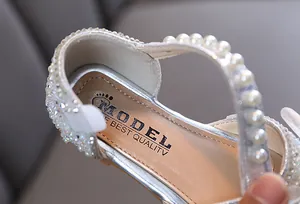 Detail van zilveren meisjes prinsessenschoen met parels en strassteentjes