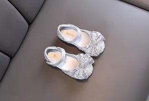 Top view of silver sparkly girl's princess shoes with glittery bow and sequin finish