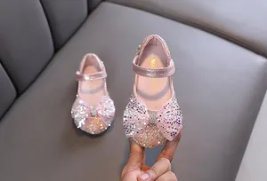 Detail view of pink sequin girl's princess shoes featuring a large sparkling bow ornament
