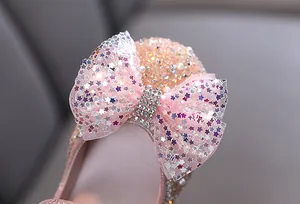 Detailed close-up showing the sequined star bow and rhinestones on pink girls' princess shoes.