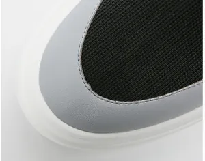 Macro detail of breathable black fly-knit men's sock sneaker with grey leather overlay