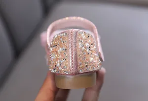 Close-up of pink girls' princess shoe heel with sparkling rhinestones and pearls.