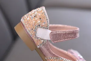 Detail of pink sparkling girl's princess shoes with sequins and pearls.