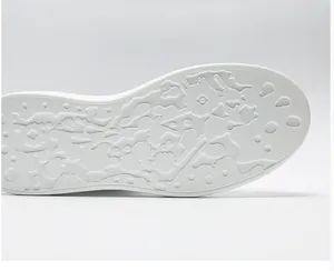 Close-up detail of white sneaker rubber sole with unique non-slip embossed splash patterns