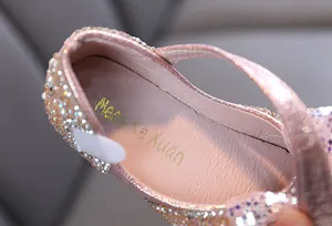 Detail view of the pink glitter girl's shoe showing the insole and rhinestone texture
