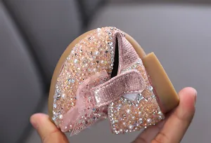 Close-up of flexible sole on pink sequined girl's princess shoes with bow
