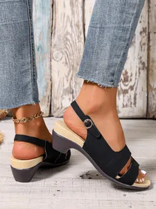 Close-up detail of black peep-toe wedge sandals with adjustable ankle buckle strap