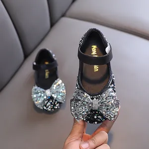 Elegant girl's princess dress shoes featuring black sequins and a large sparkly bow.