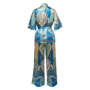 Rear view of faux silk printed two-piece set featuring wide-leg pants and a belted top.