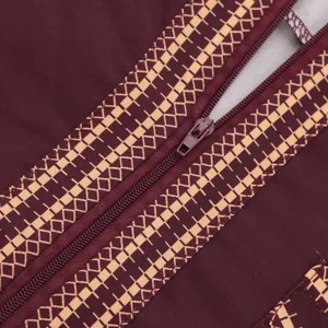 Macro view of traditional robe showing ethnic print and zipper detail on burgundy fabric