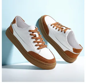 Vue latérale de baskets rétro en cuir blanc et marron pour homme avec semelle gomme.