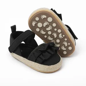 Detalle de zapatos negros de paseo para bebé con volantes y suela antideslizante dibujos