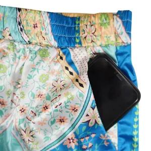 Detail view of boho floral print faux silk pants featuring a functional side pocket