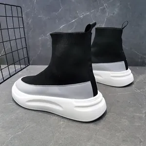 Close-up of breathable black high-top knit sock sneakers with thick white soles.