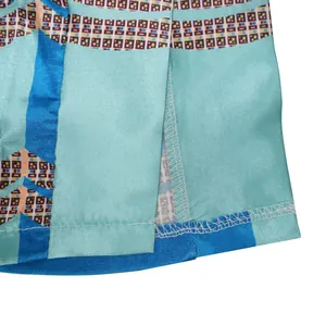 Close-up detail of reinforced hem stitching on printed faux silk wide-leg trousers.