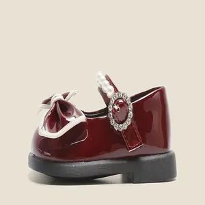 Detail of burgundy toddler girl's Mary Jane with pearl and rhinestone buckle strap.