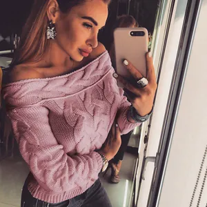 Close-up detail of a pink off-the-shoulder cable knit sweater featuring thick texture