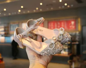 Macro view of girls' sparkly pink princess dress shoes with a shiny diamond bow