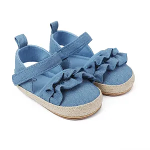 Detalle de zapatos de bebé en mezclilla azul con elegantes volantes y suelas tejidas