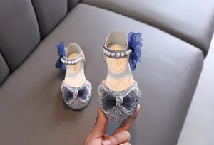 Nahaufnahme blauer Prinzessinnenschuhe für Mädchen mit Paillettenschleife und Perlen
