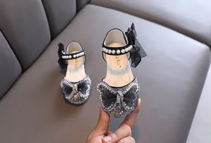 Nahaufnahme von Prinzessinnenschuhen für Mädchen mit Glitzersteinen und Schleife