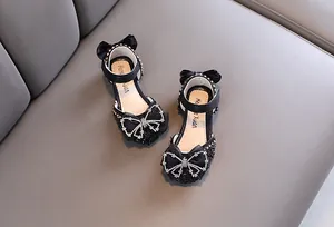 Vista dettagliata di eleganti scarpe da principessa nere per bambine con fiocchi di strass