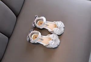 Dettaglio scarpe da principessa argento glitterate per bambina con fiocco e strass eleganti