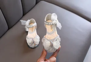 Detailansicht der weißen Prinzessinnenschuhe für Mädchen mit Perlen und Strassschleife.